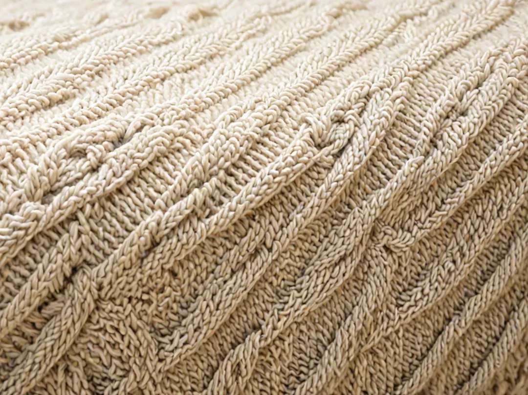 Detail of knitted cables on a white sweater